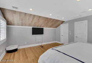 a bedroom with a bed and a flat screen tv