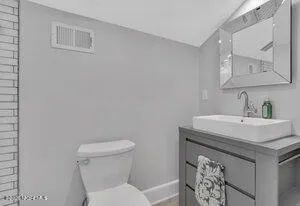 a bathroom with a sink a toilet and a mirror