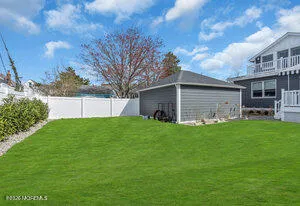 a view of a backyard with plants and large tree