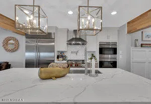 a kitchen with stainless steel appliances kitchen island a chandelier and fireplace