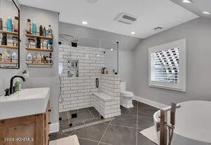 a bathroom with a sink a toilet and shower