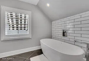 a bathroom with bathtub and window
