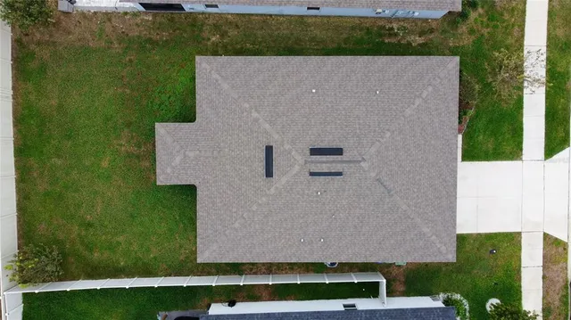 an aerial view of a house with a yard