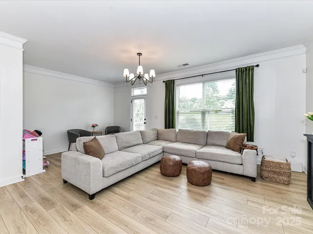 a living room with furniture and a chandelier