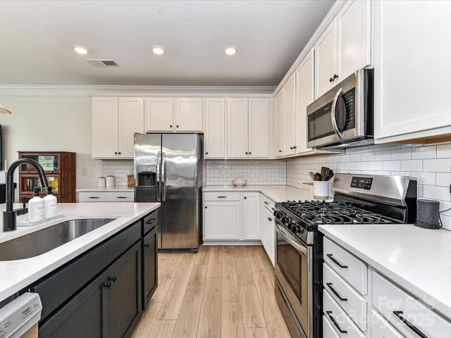 a kitchen with stainless steel appliances granite countertop a sink stove microwave and cabinets
