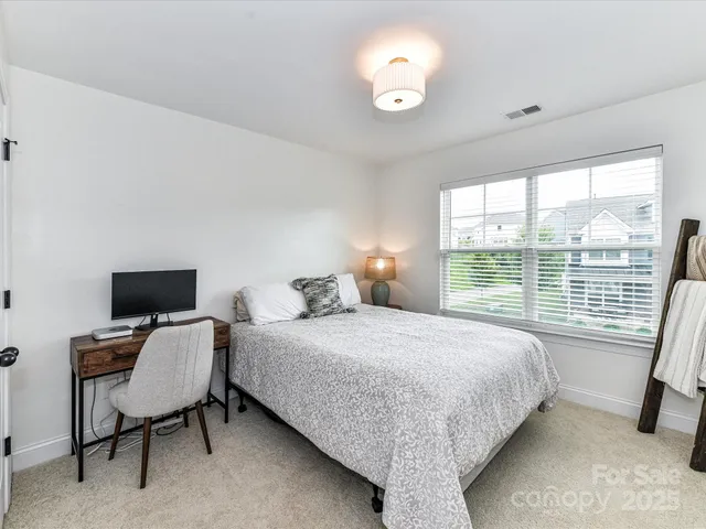 a bedroom with a bed and a large window