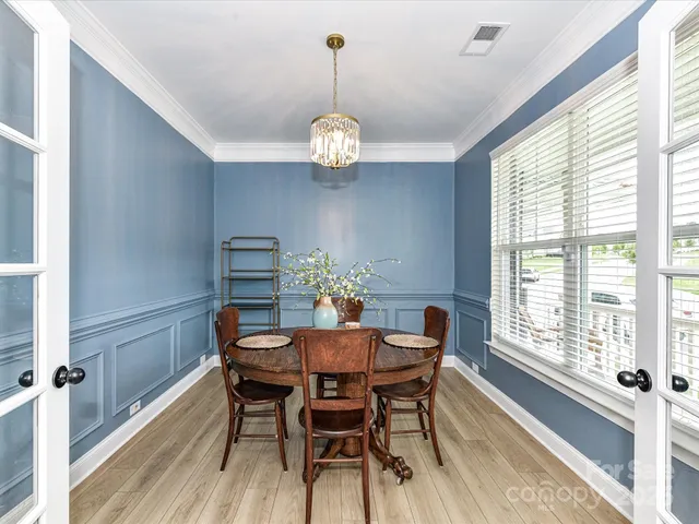 a view of a dining room with furniture wooden floor and chandelier