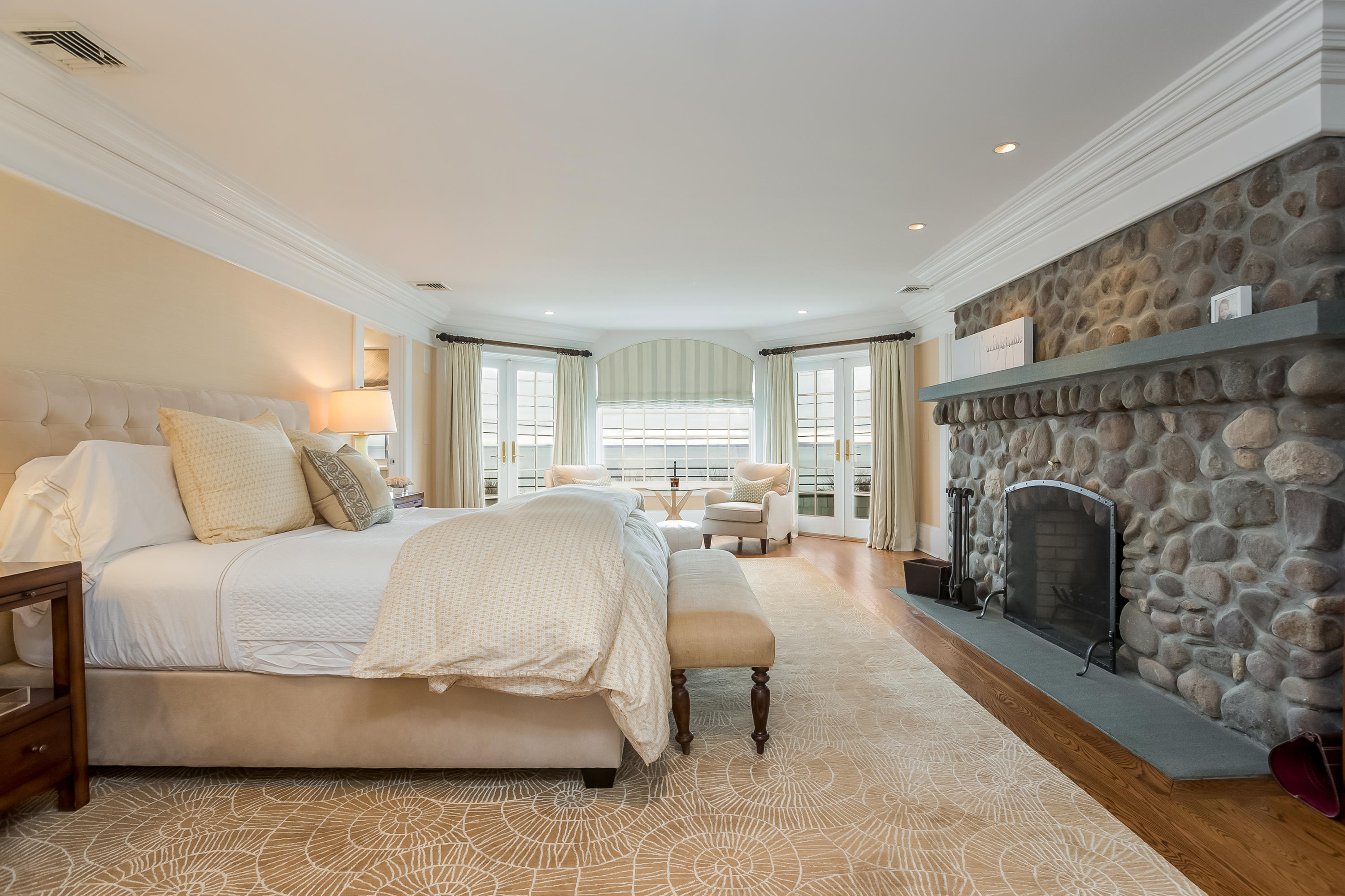 13 Crescent Beach Road Rowayton, CT 06853 - Photo 21 of 40 a spacious bedroom with a balcony a bed and a fireplace