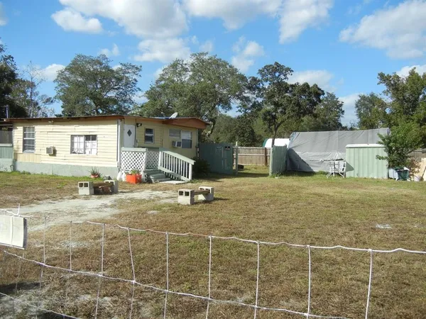 a view of a house with backyard and sitting area