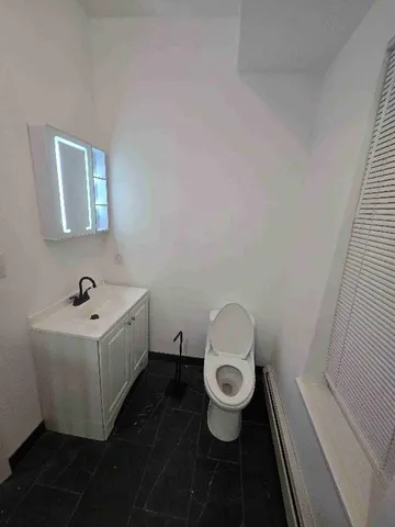 a bathroom with a sink toilet and mirror