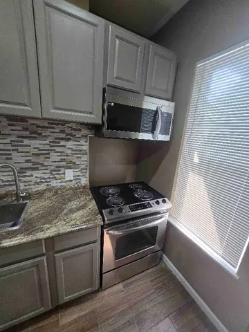 a kitchen with granite countertop cabinets stainless steel appliances and a sink