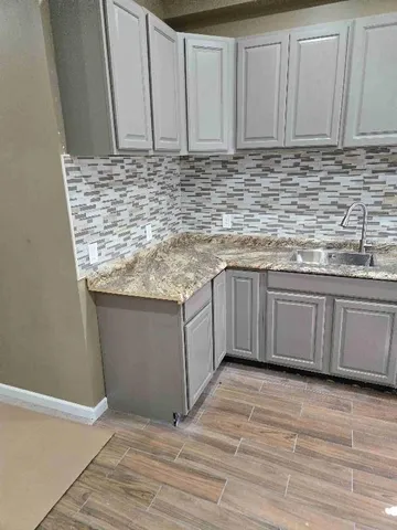 a kitchen with stainless steel appliances granite countertop a sink a stove top oven and granite counter tops