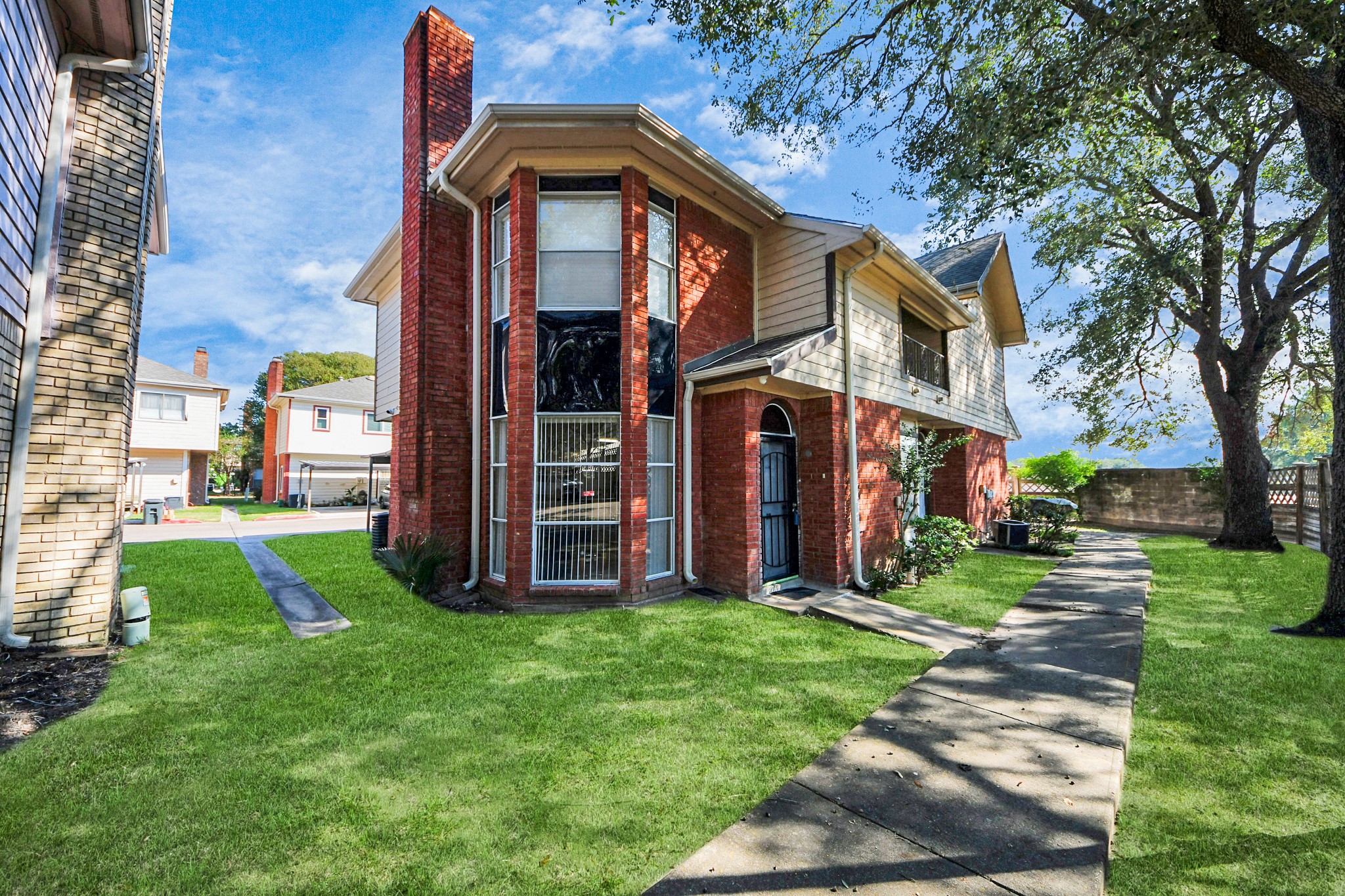13620 Rosewood Street, Unit 3A Houston, TX 77083 - Photo 1 of 25 a front view of a house with a yard