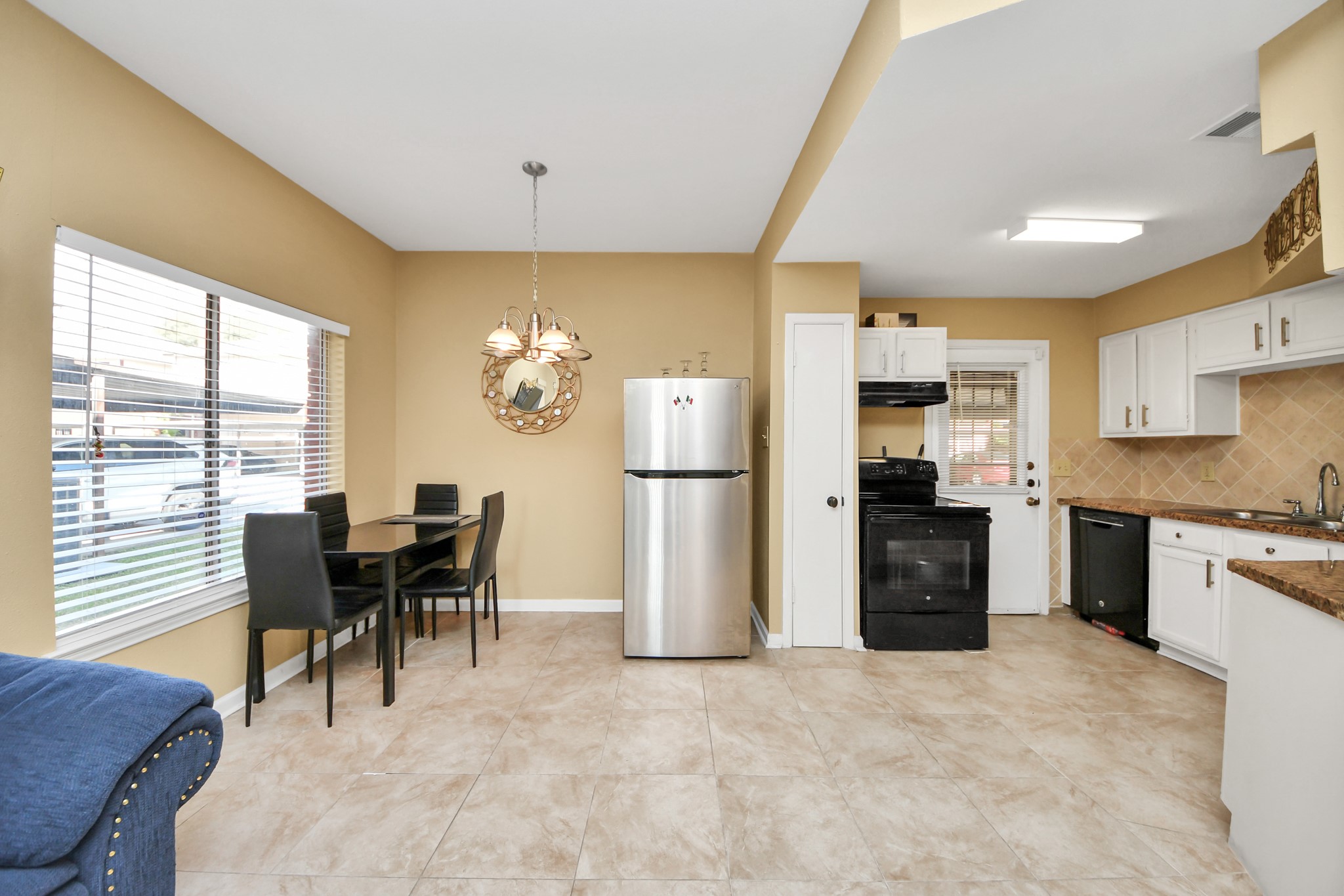 13620 Rosewood Street, Unit 3A Houston, TX 77083 - Photo 14 of 25 a kitchen with refrigerator cabinets dining table and chairs
