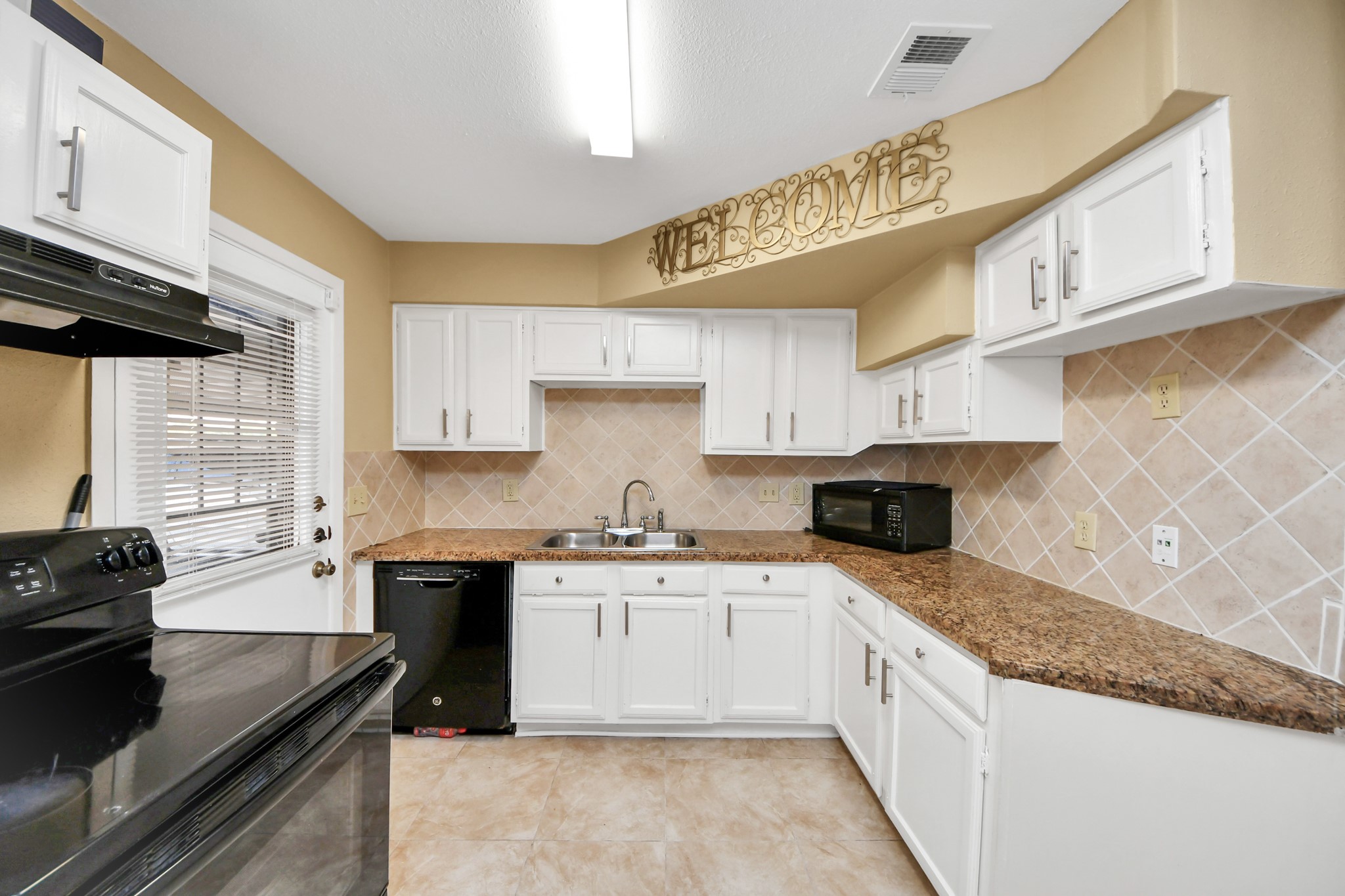 13620 Rosewood Street, Unit 3A Houston, TX 77083 - Photo 16 of 25 a large kitchen with stainless steel appliances granite countertop a sink a stove and a wooden cabinets
