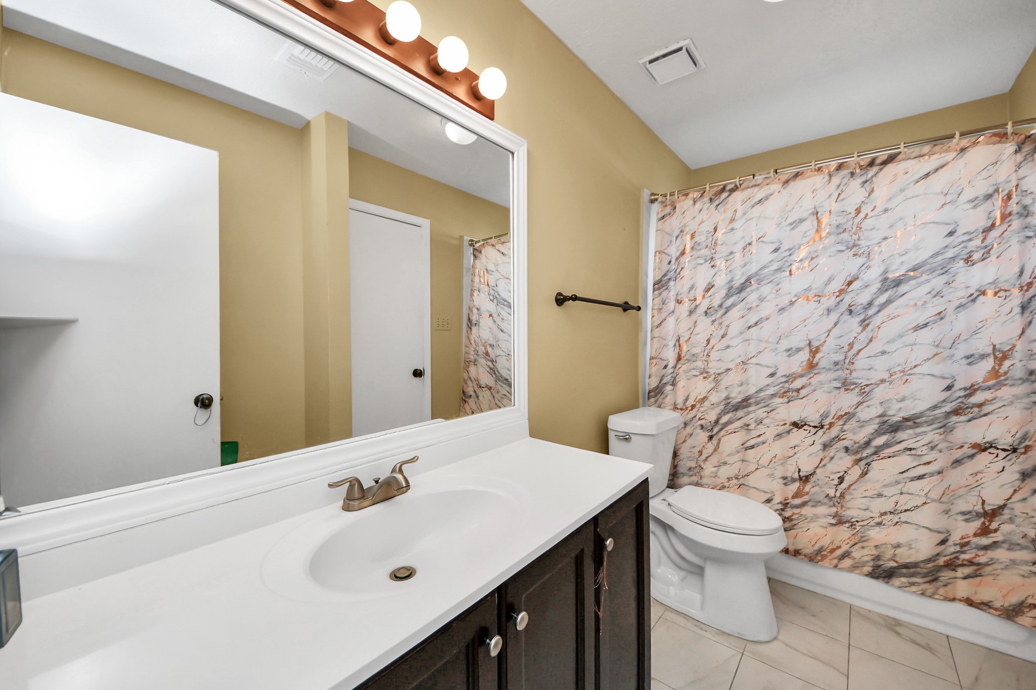 13620 Rosewood Street, Unit 3A Houston, TX 77083 - Photo 22 of 25 a bathroom with a sink a toilet and shower curtain