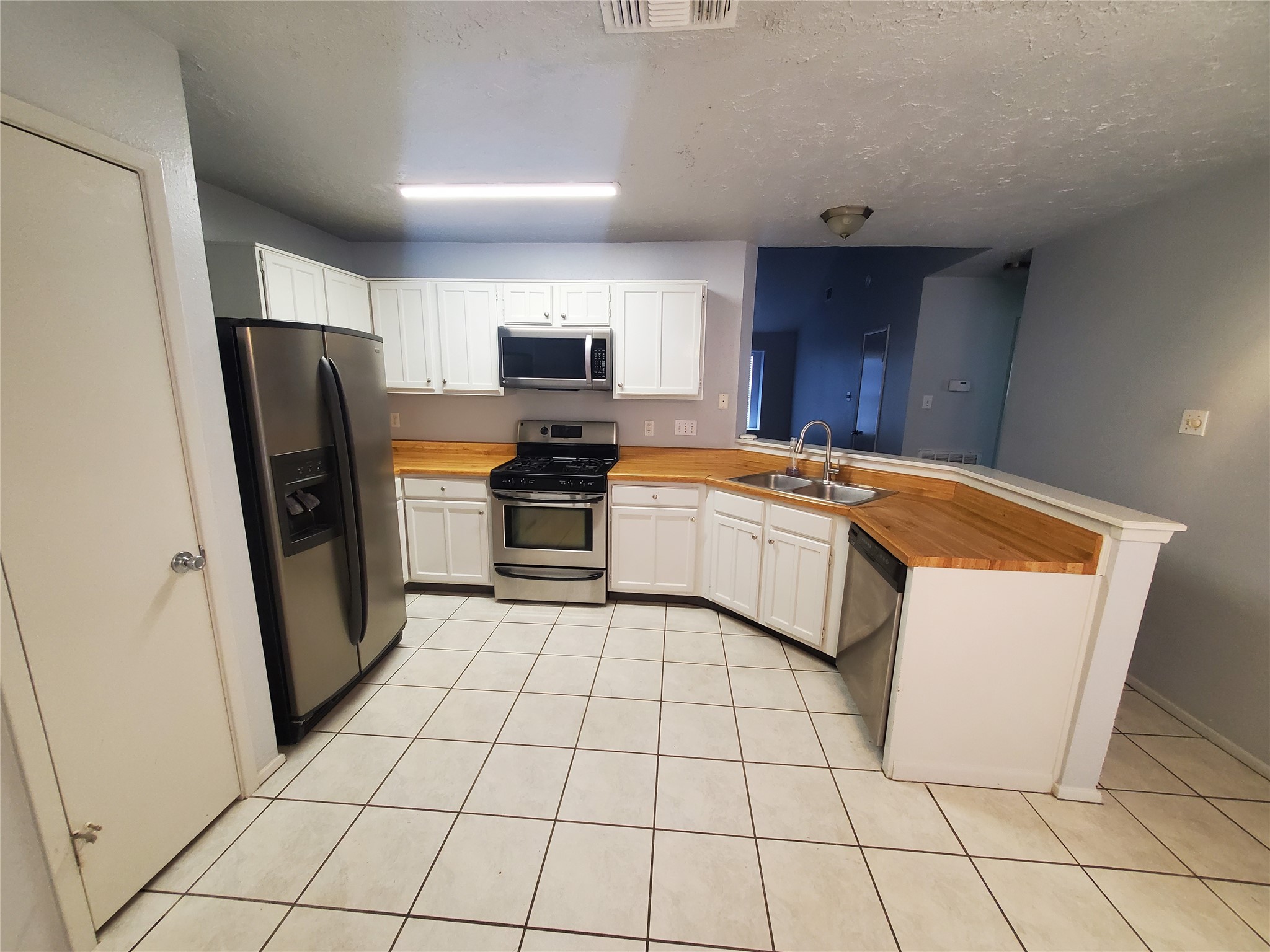 2306 Spring Dusk Drive Spring, TX 77373 - Photo 6 of 12 a kitchen with stainless steel appliances a refrigerator sink and microwave