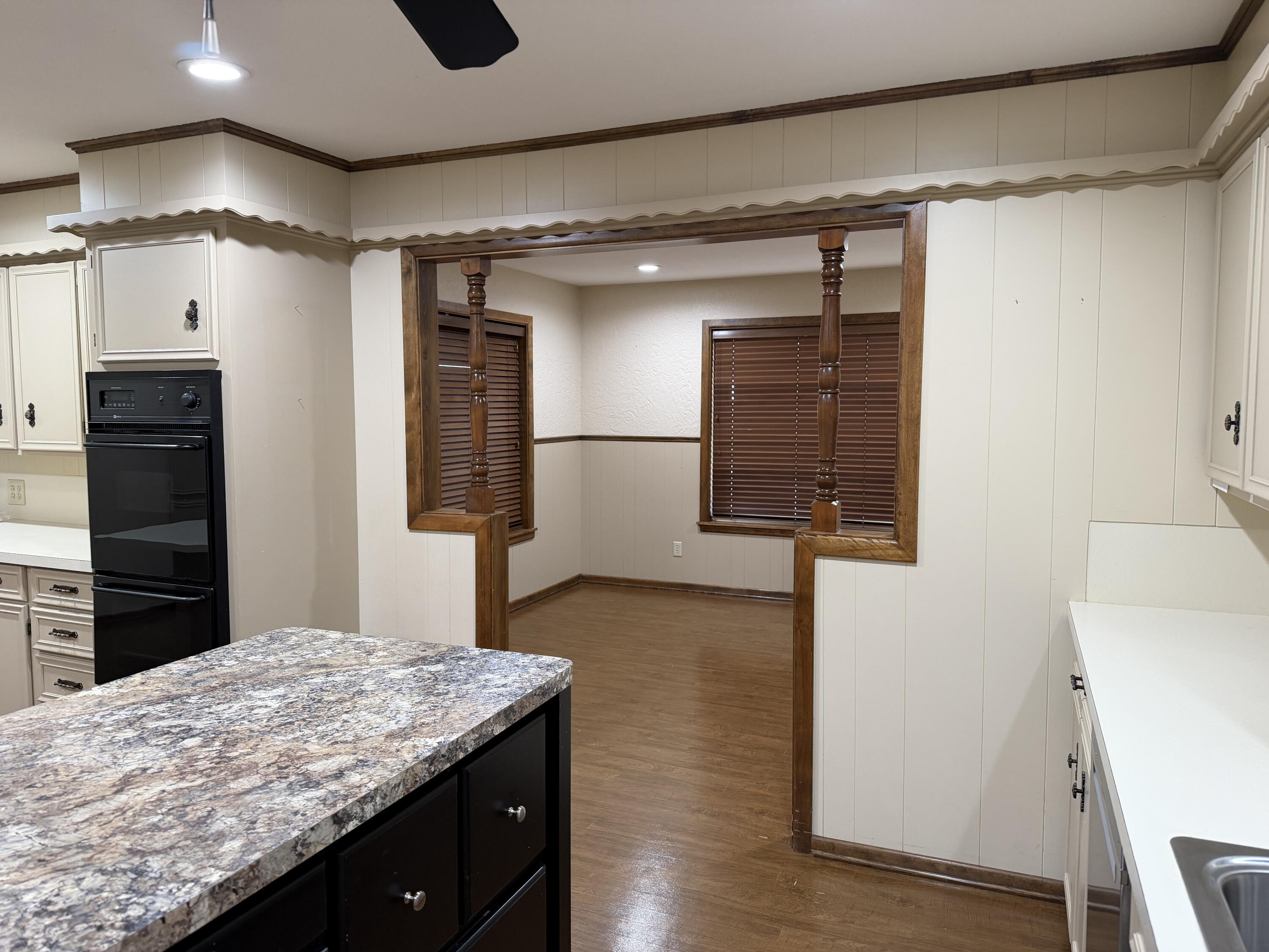 1603 South 8th Street Lamesa, TX 79331 - Photo 7 of 39 a kitchen with kitchen island a counter top space wooden floor and stainless steel appliances