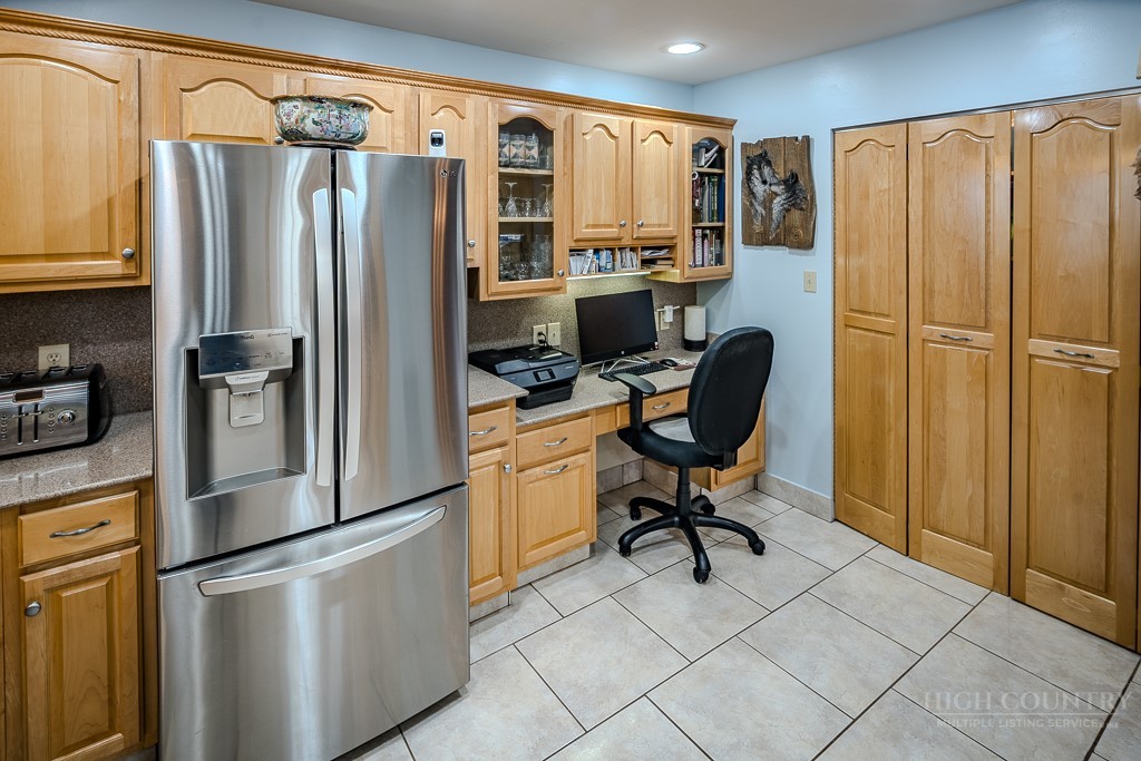 103-105 Upper Grouse Ridge Road Beech Mountain, NC 28604 - Photo 11 of 48 a kitchen with stainless steel appliances a refrigerator sink and cabinets