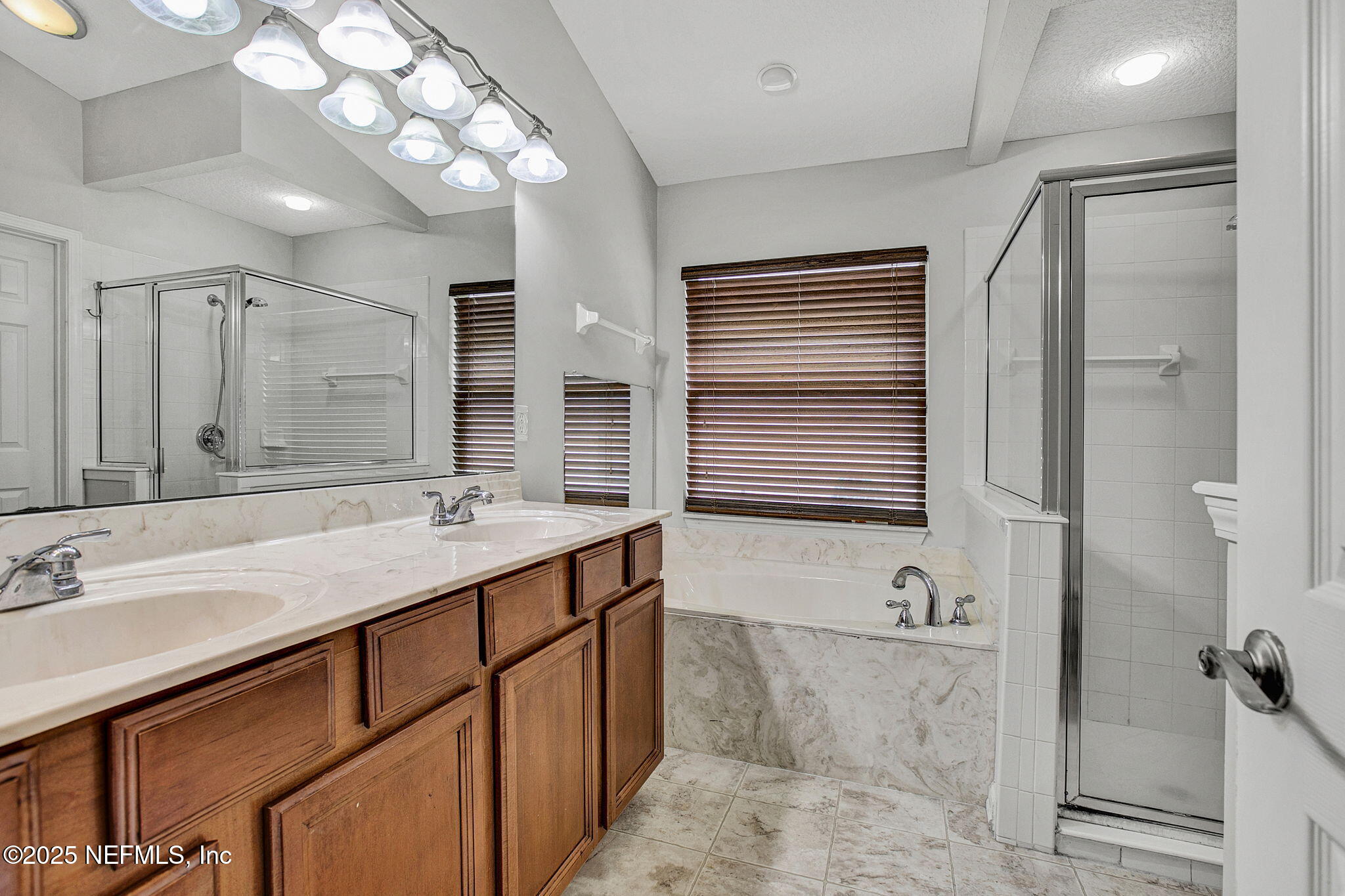 939 Silver Spring Court St. Augustine, FL 32092 - Photo 27 of 31 a bathroom with a granite countertop sink a mirror and a shower