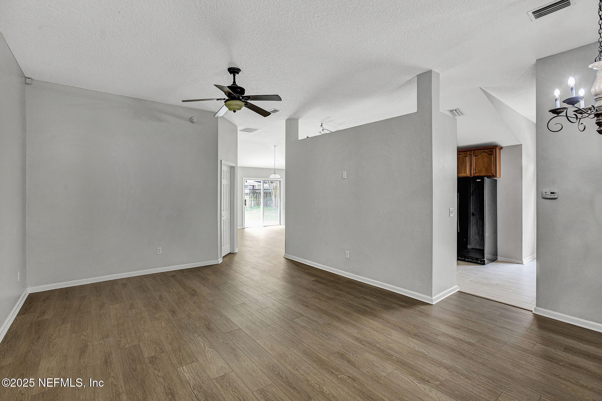 939 Silver Spring Court St. Augustine, FL 32092 - Photo 5 of 31 a view of a hallway with wooden floor and a chandelier fan