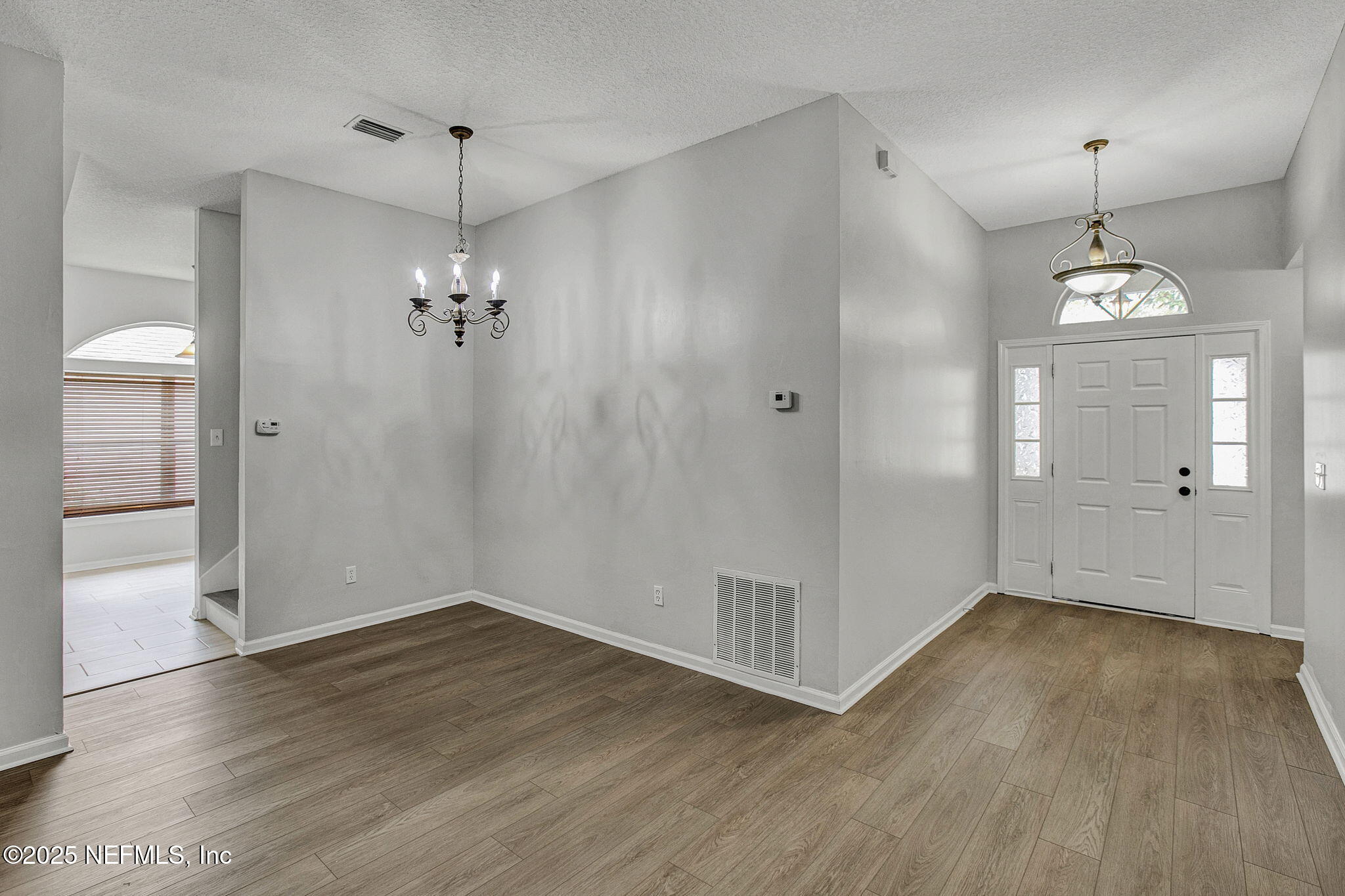939 Silver Spring Court St. Augustine, FL 32092 - Photo 6 of 31 an empty room with wooden floor and mirror