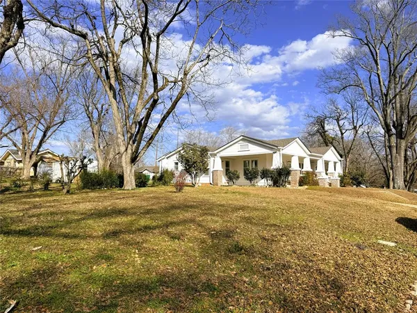 a front view of residential houses with yard and trees