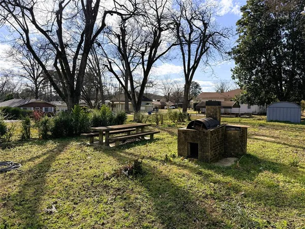 a backyard of a house with barbeque oven and outdoor seating