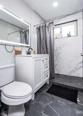 a bathroom with a sink a toilet and shower