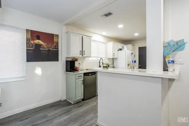a kitchen with a sink a refrigerator and cabinets