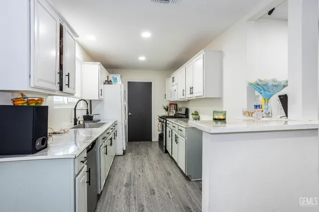 a kitchen with stainless steel appliances a sink stove refrigerator and cabinets