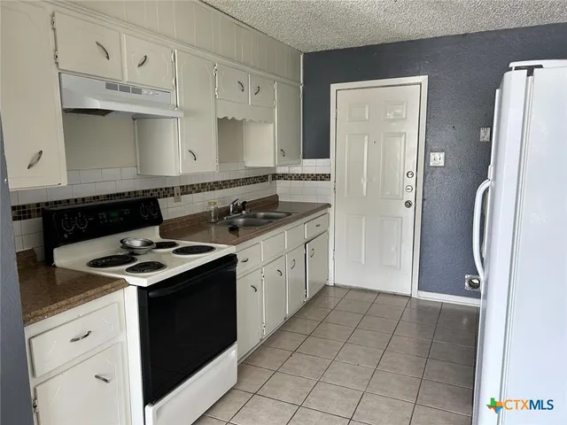 a kitchen with stainless steel appliances granite countertop a stove and a refrigerator
