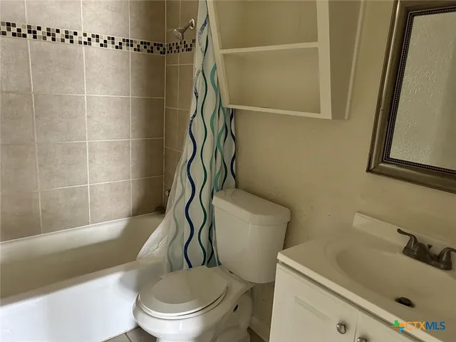 a white toilet sitting next to a bath tub and shower