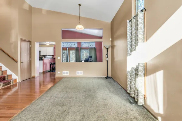 a view of a big room with wooden floor and a kitchen