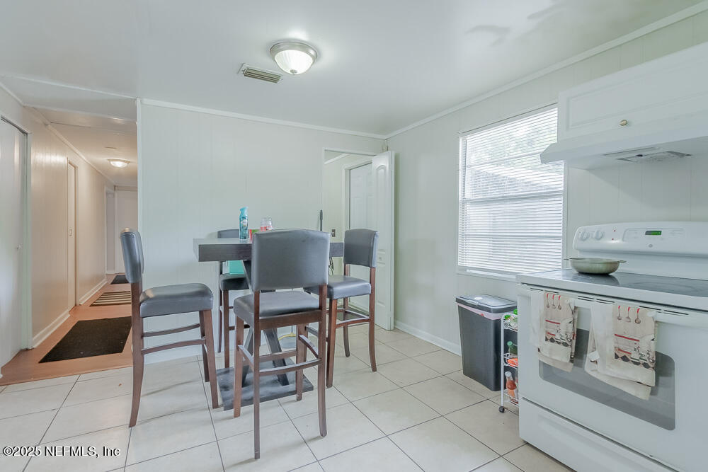 9042 7th Avenue Jacksonville, FL 32208 - Photo 11 of 22 a view of a kitchen with dining area cabinets and a sink