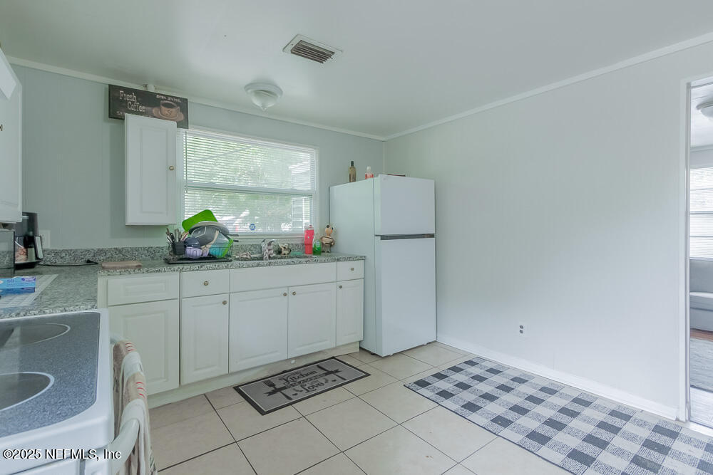 9042 7th Avenue Jacksonville, FL 32208 - Photo 10 of 22 a room with a white cabinets a sink and a window