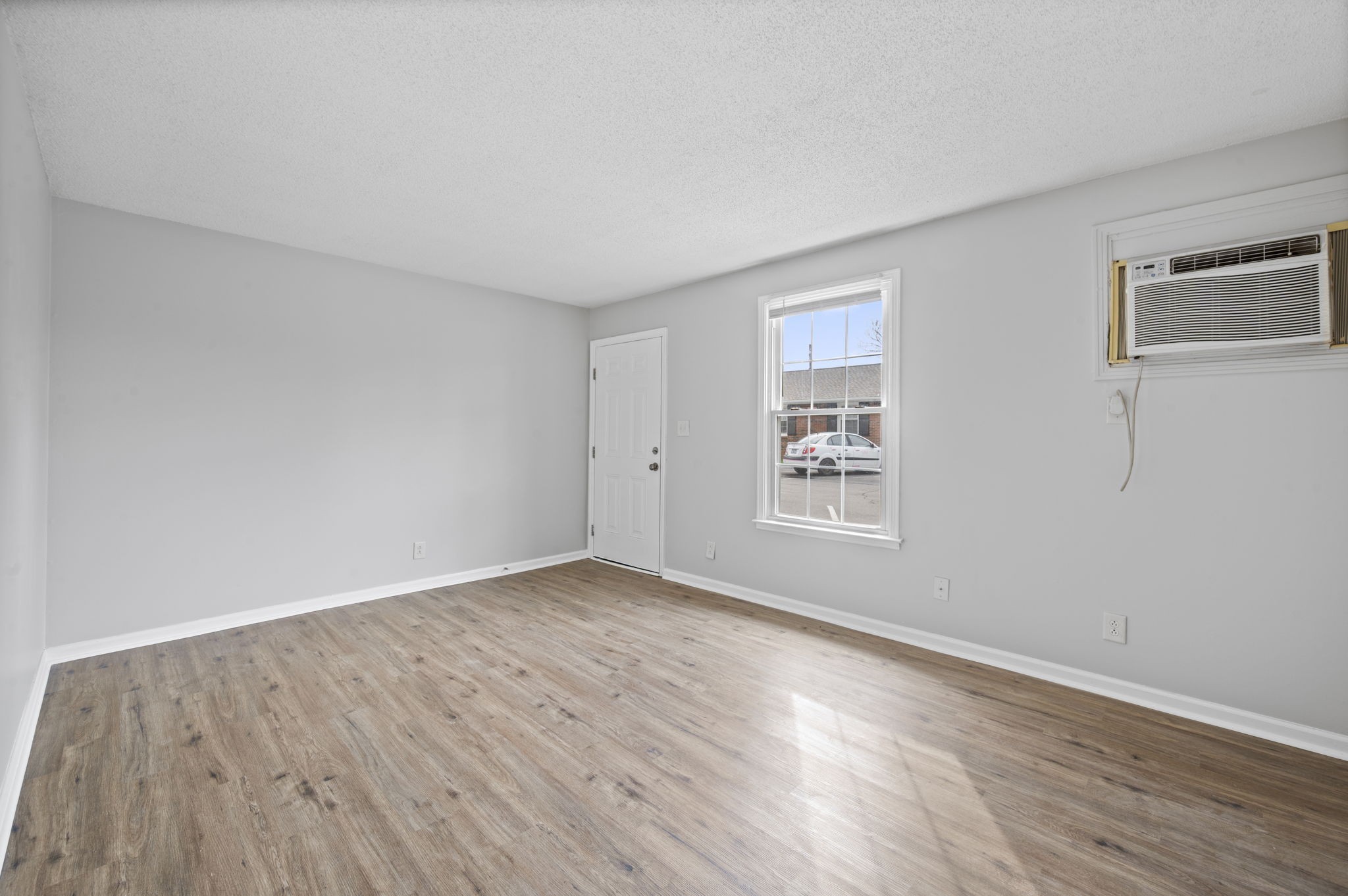 703 Power Street, Unit B Clarksville, TN 37042 - Photo 7 of 13 a view of an empty room with wooden floor and a window