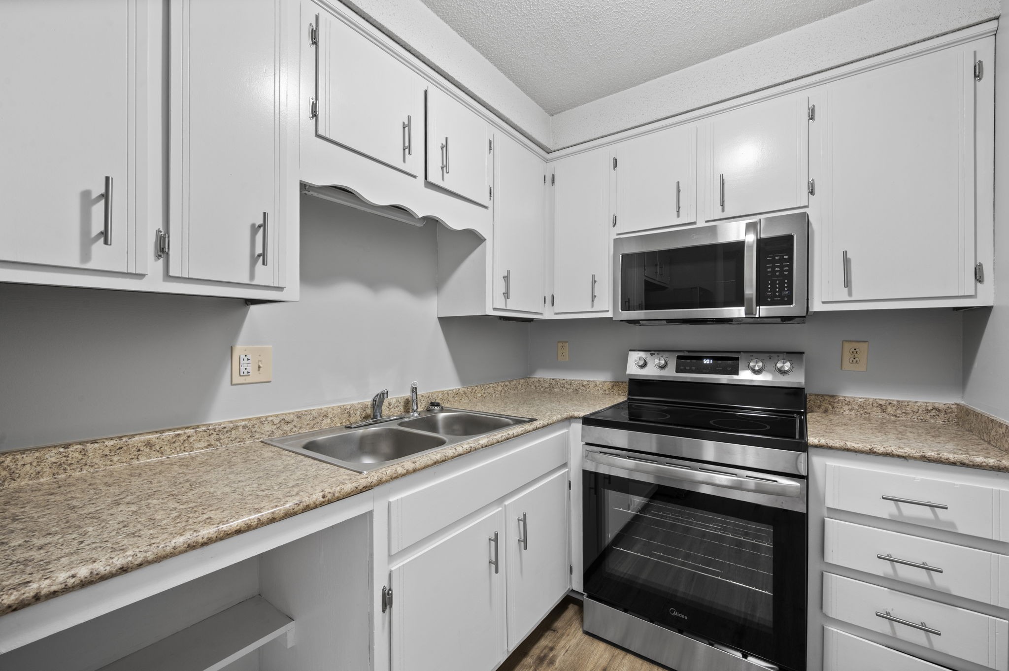 703 Power Street, Unit B Clarksville, TN 37042 - Photo 9 of 13 a kitchen with granite countertop a sink stainless steel appliances and white cabinets