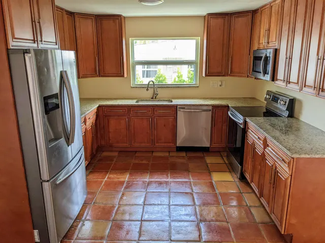 a kitchen with stainless steel appliances granite countertop a refrigerator and a sink