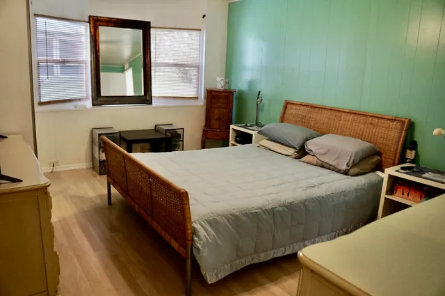 a bedroom with 2 bed and a window