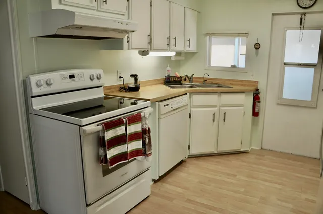 a kitchen with cabinets appliances and a wooden floor