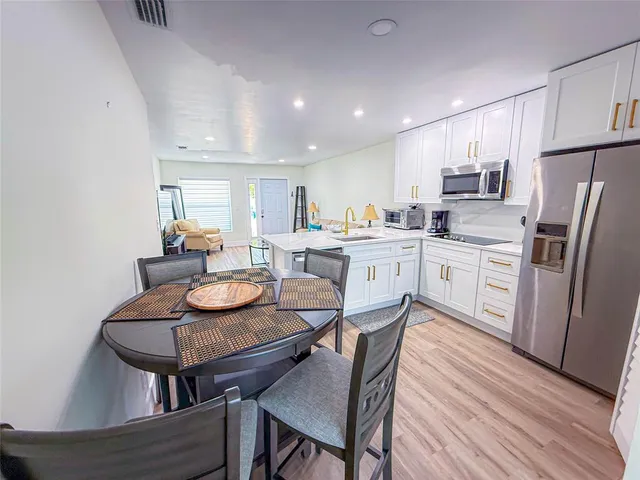 a kitchen with stainless steel appliances kitchen island granite countertop a kitchen island a stove a table and chairs