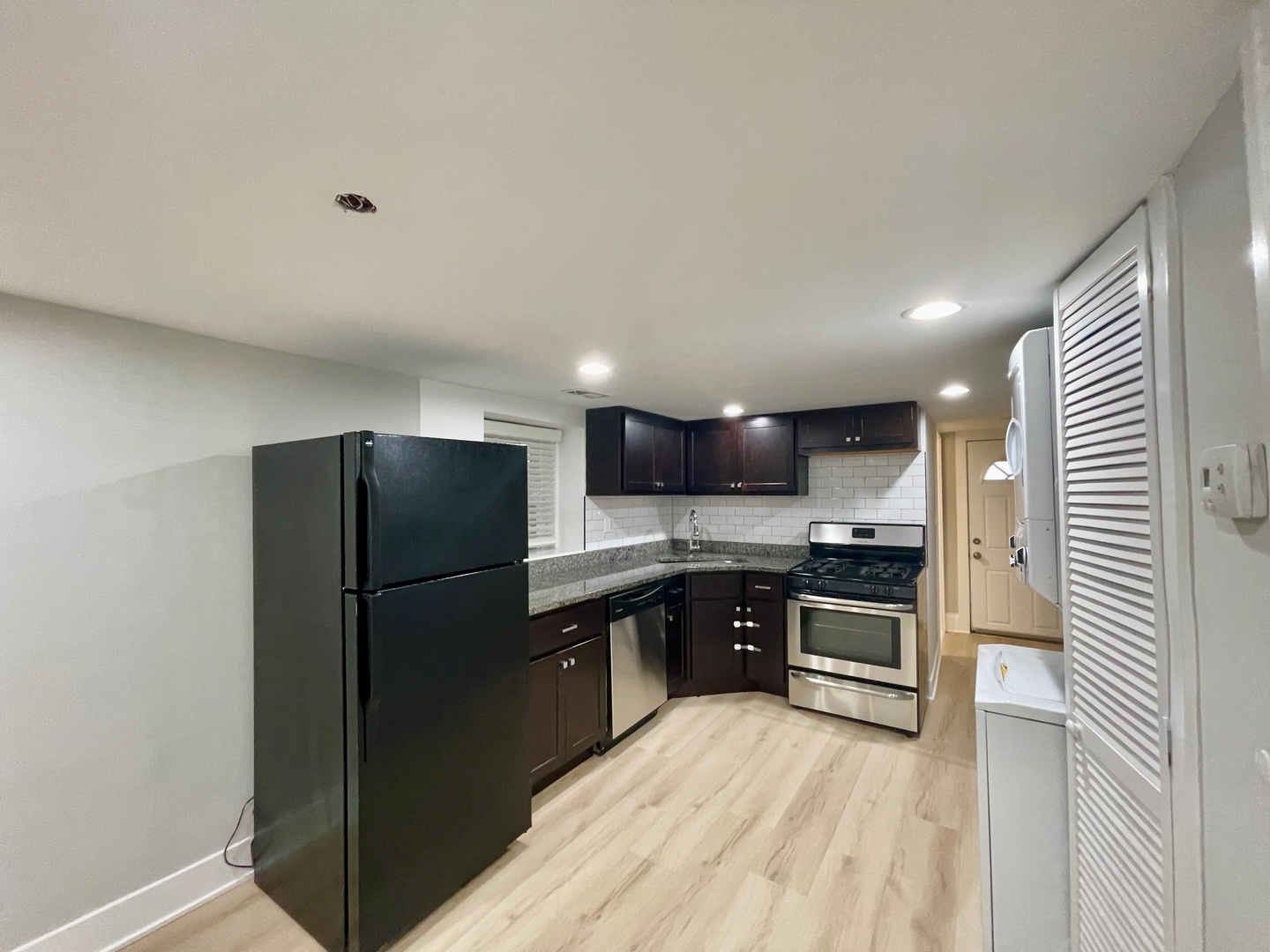 2239 West 19th Street, Unit G Chicago, IL 60608 - Photo 3 of 17 a kitchen with stainless steel appliances granite countertop a refrigerator a stove a sink and a microwave
