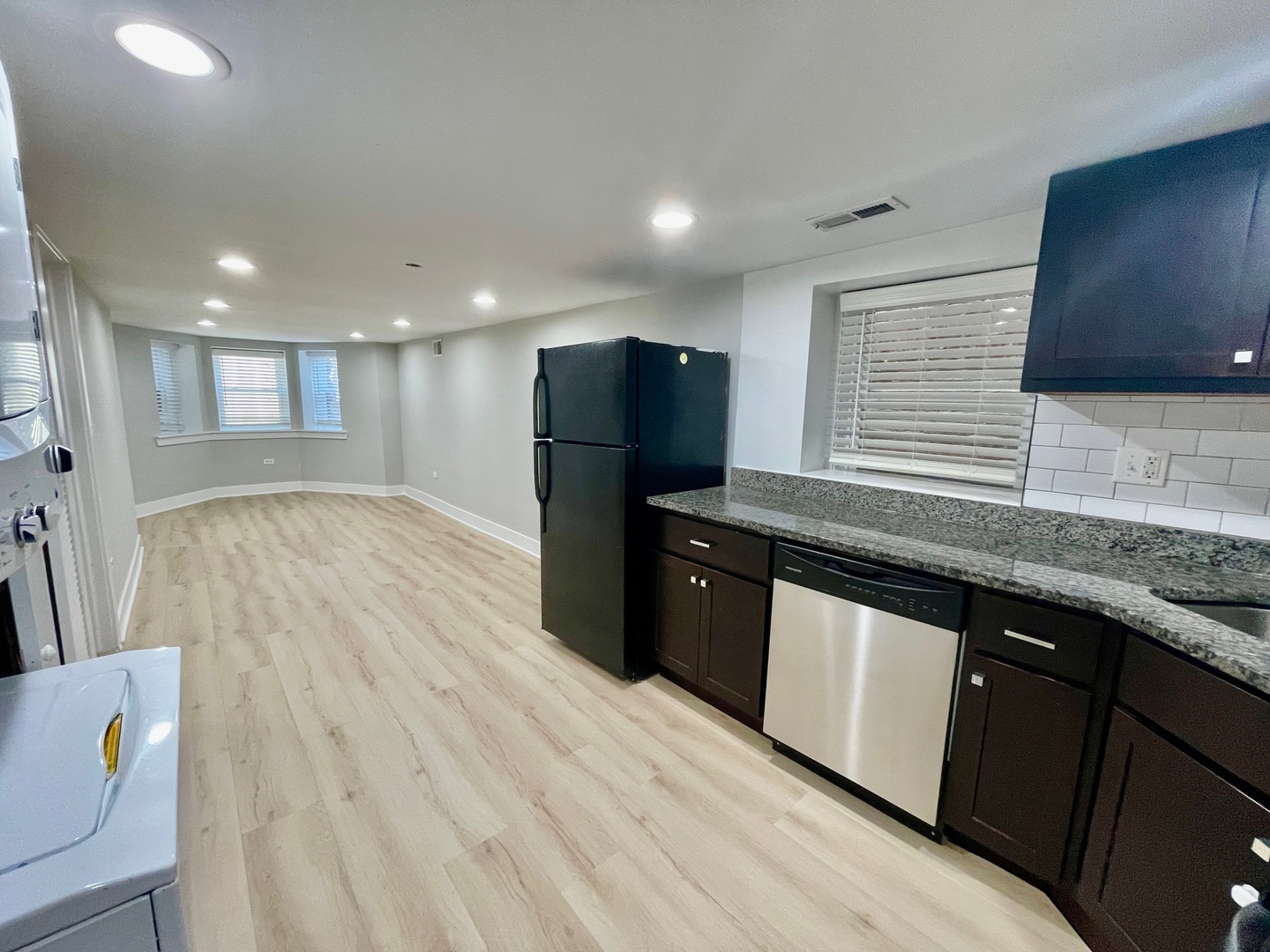 2239 West 19th Street, Unit G Chicago, IL 60608 - Photo 6 of 17 a kitchen with granite countertop a refrigerator a sink and wooden floors