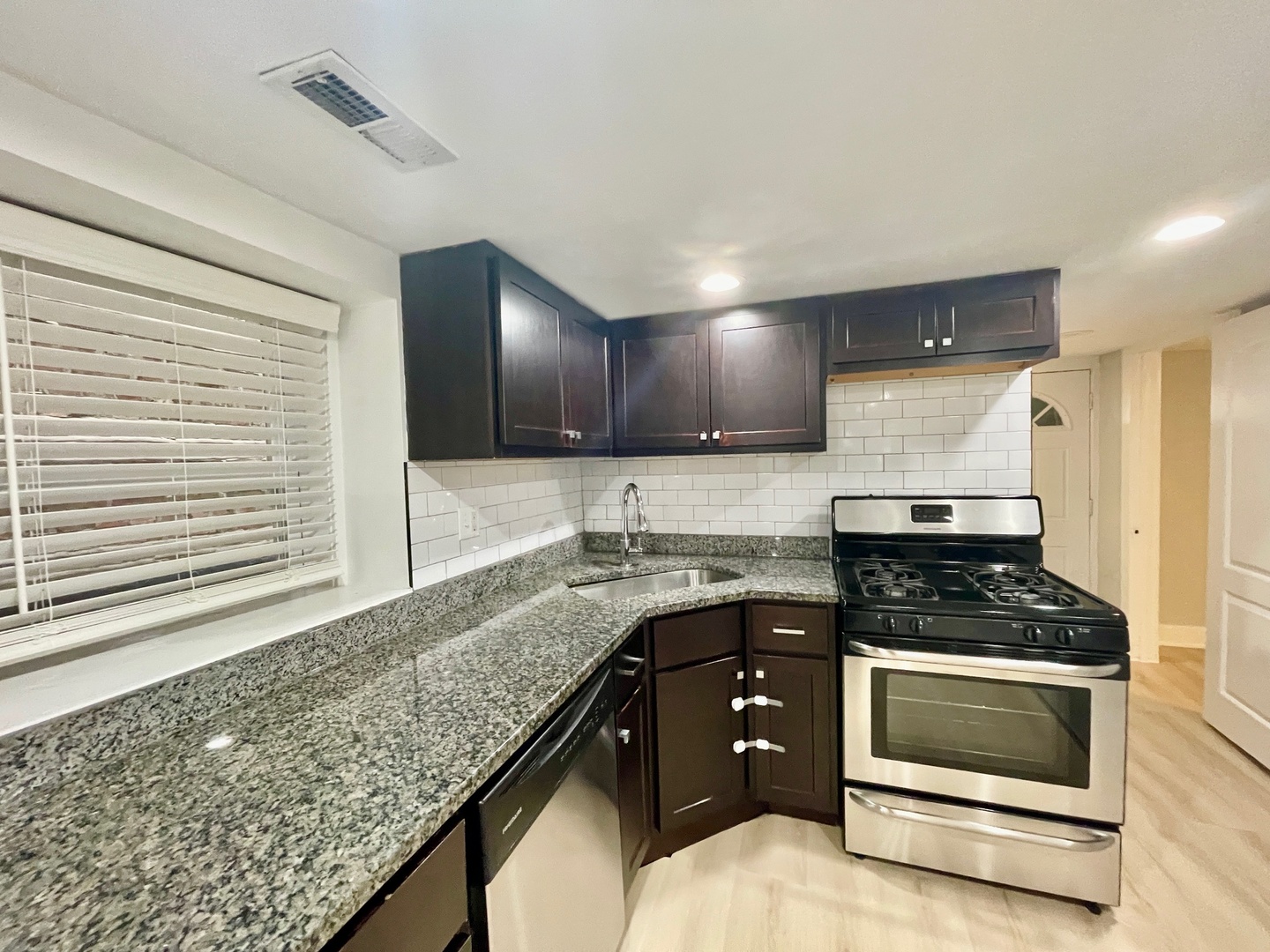 2239 West 19th Street, Unit G Chicago, IL 60608 - Photo 8 of 17 a kitchen with granite countertop a stove and cabinets