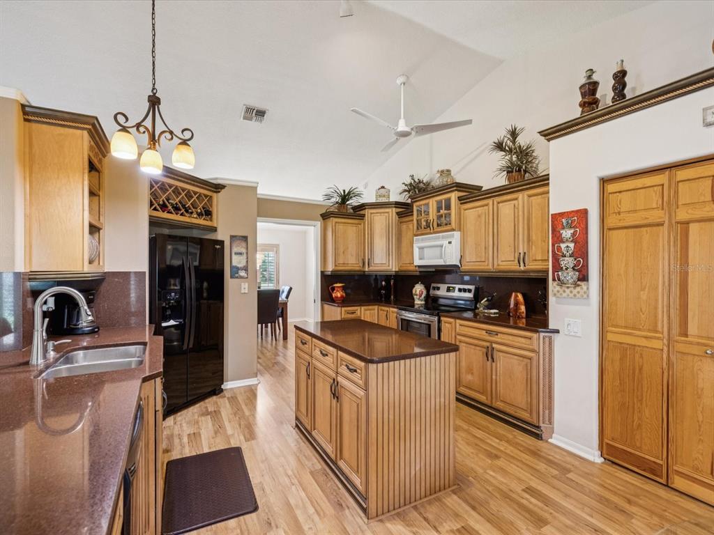 8401 Pavilion Drive Hudson, FL 34667 - Photo 16 of 81 a kitchen with stainless steel appliances granite countertop a refrigerator a stove and a sink with wooden floor