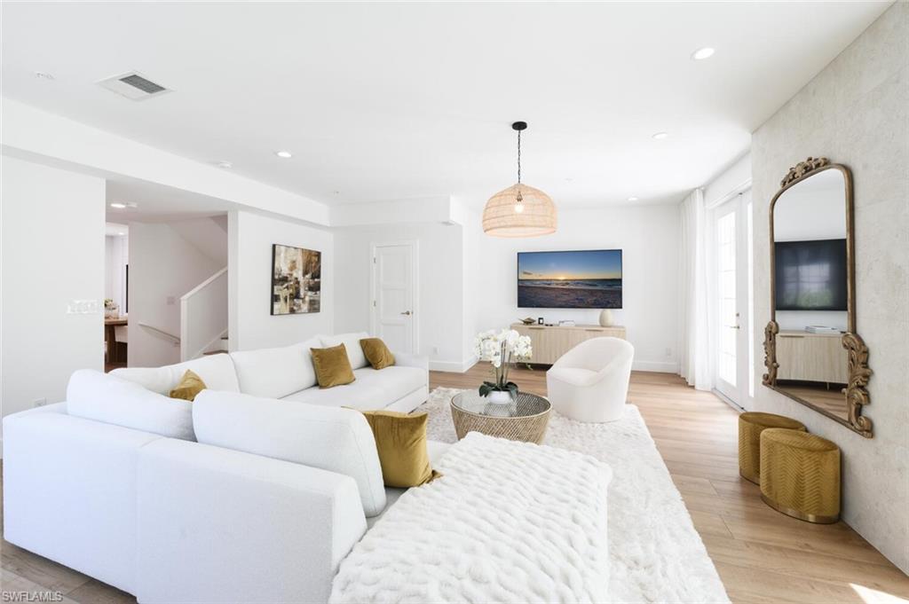 888 10th Street South, Unit 101 Naples, FL 34102 - Photo 11 of 44 a living room with furniture kitchen view and a wooden floor