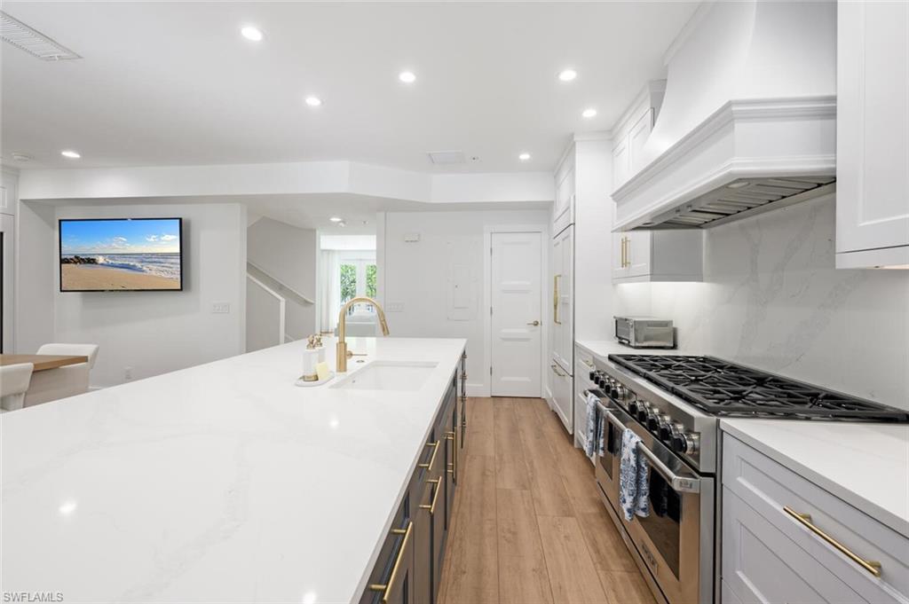 888 10th Street South, Unit 101 Naples, FL 34102 - Photo 12 of 44 a kitchen with kitchen island stainless steel appliances sink stove and cabinets