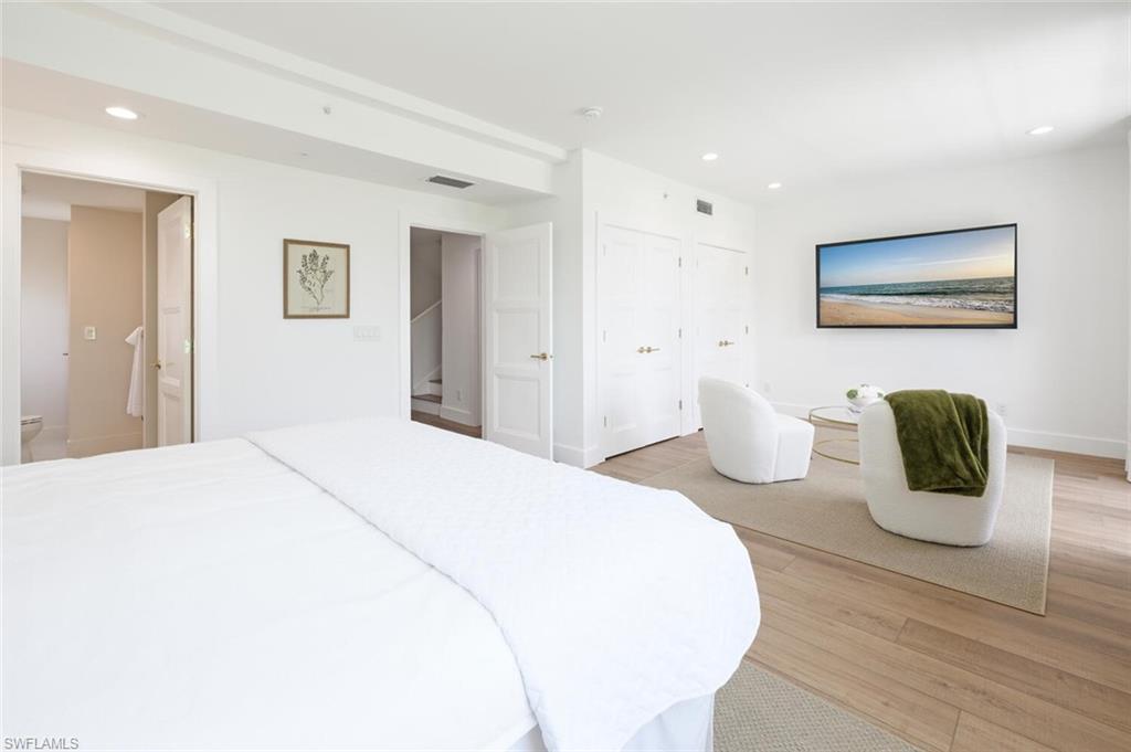 888 10th Street South, Unit 101 Naples, FL 34102 - Photo 26 of 44 a bedroom with a bed and wooden floor