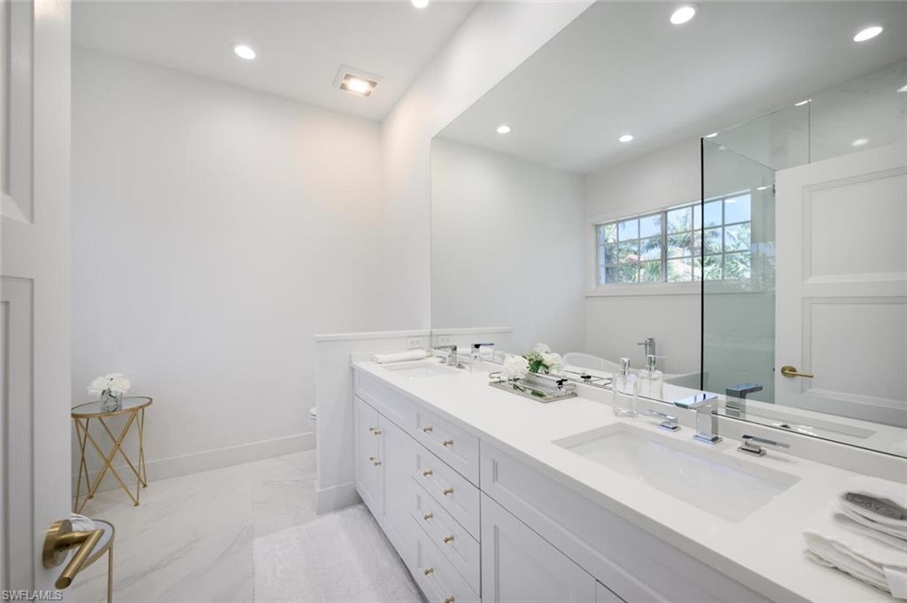 888 10th Street South, Unit 101 Naples, FL 34102 - Photo 27 of 44 a bathroom with a sink double vanity and a mirror